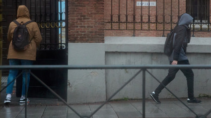 Dos hombres se protegen de la lluvia con capuchas