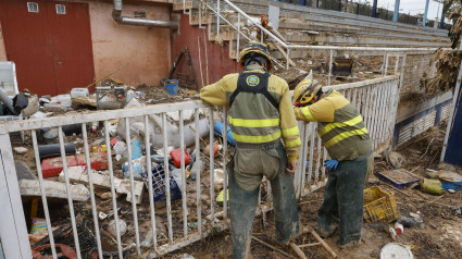 Varios bomberos trabajan en la limpieza del polideportivo municipal en Paiporta