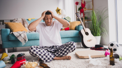 Foto de un chico impresionado y funky en pijama sintiéndose mal después de una fiesta en una casa en un apartamento