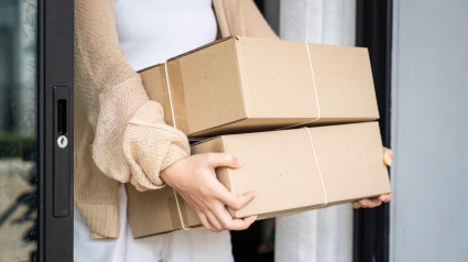 Mujer recibiendo paquete en la puerta, Entrega de pedido online a domicilio