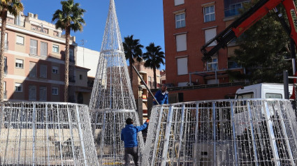 Operarios instalan algunos de los árboles luminosos del ayuntamiento de Lorca