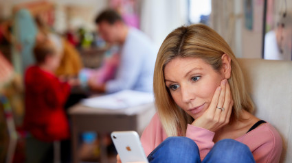 Mujer mirando a través de su teléfono móvil