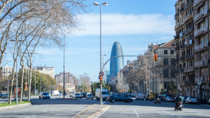 Vista de una calle de Barcelona con coches, gente y edificios modernos, Cataluña