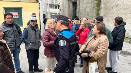 Un policía Local habla con gente que esperaba para conseguir las entradas