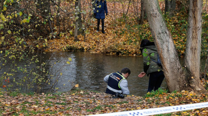 Agentes de la Policía Nacional buscan pruebas en las orillas del río Arlanzón.