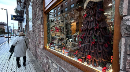 Árbol de Navidad hecho con chorizos y guindillas en el escaparate de una tienda de embutidos de Gijón