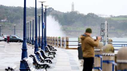 Una persona graba el oleaje en el puerto de Santander.