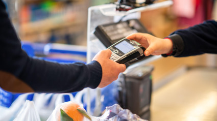 Joven pagando en un supermercado