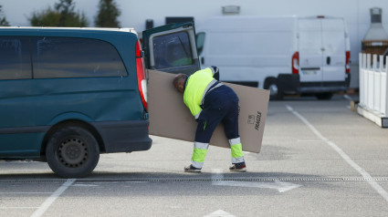 Un repartidor mete un paquete en la furgoneta