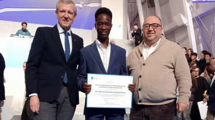 Ibrahima posa con su diploma junto al presidente de la Xunta y el director de los centros San Aníbal, Jesús Iglesias