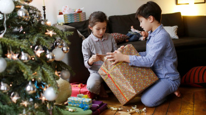 Niños abriendo sus regalos en la mañana de Reyes