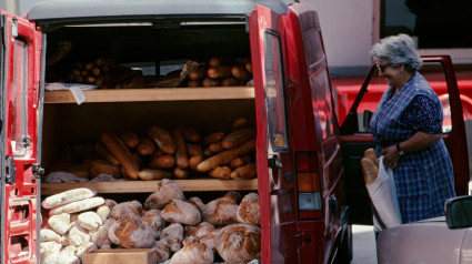 Mujer comprando pan en una camioneta de panadería móvil