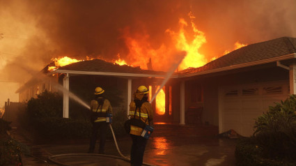 Bomberos luchan contra el fuego en el barrio de Palisades, en Los Ángeles