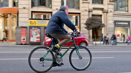 Ciclista urbano con una bicicleta de montaña en la calle Gran vía.