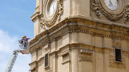 Imagen de una de las torres del Pilar con dos operarios estudiándola.