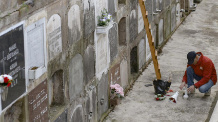 Un hombre prepara un ramo en el cementerio de Ceares, en Gijón