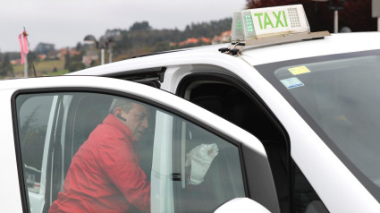 Taxista limpia su coche en una parada de Gijón