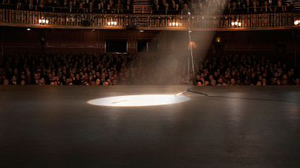 Foco que apunta al escenario de una sala de teatro