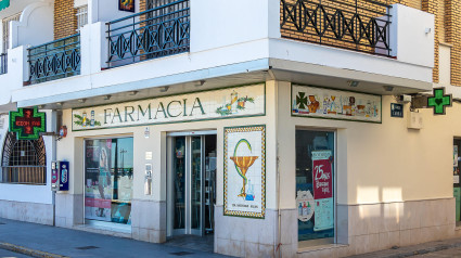 Farmacia española abierta. Tienda farmacéutica con cruz verde iluminada.