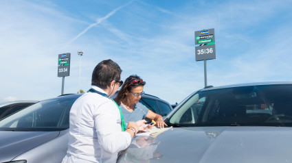 Turista firmando un contrato de alquiler de coches de Enterprise en el aeropuerto de Barcelona El Prat