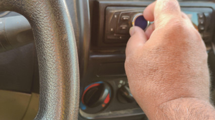 Hombre conduciendo usando una radio de coche