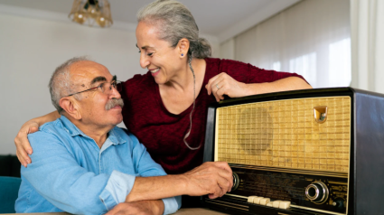 Pareja escuchando una radio antigua