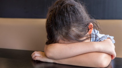 Niña cansada durmiendo en el escritorio o mesa