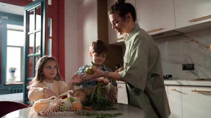 Niños en la cocina de casa con alimentos frescos y saludables