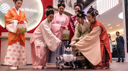 3A0D34E Barcelona, Spain. 3rd Mar, 2025. Hostesses in traditional dresses are seen with 'XiaoLi', a robotic dog, at the China Mobile Ltd booth during the Mobile World Congress 2025 in Barcelona, one of the most important events for mobile technologies and a launching pad for smartphones, future technologies, devices, and peripherals. Credit: Matthias Oesterle/Alamy Live News