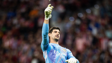 Courtois retira del terreno de juego uno de los mecheros que le lanzaron durante el derbi.
