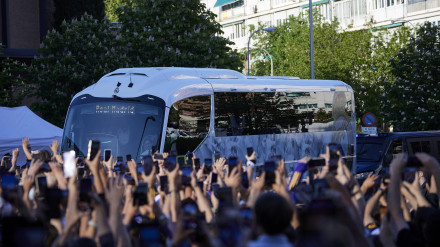 El autobús del Real Madrid, rodeado de aficionados, llega al Santiago Bernabéu antes de un partido.