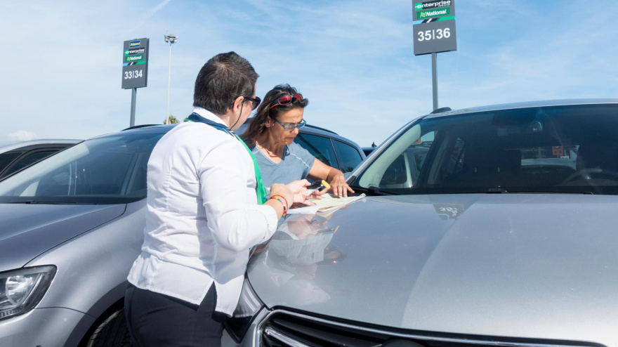 Turista firmando un contrato de alquiler de coches de Enterprise en el aeropuerto de Barcelona El Prat