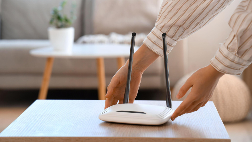 Una mujer coge un router wifi para moverlo y conseguir una mejor conexión
