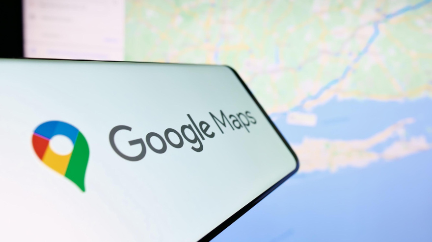 2P92MH0 Smartphone with logo of web mapping platform Google Maps on screen in front of website. Focus on center-right of phone display.