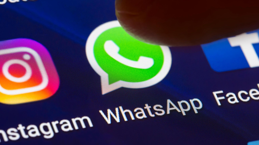 Un hombre toca el icono de WhatsApp en la pantalla de su smartphone
