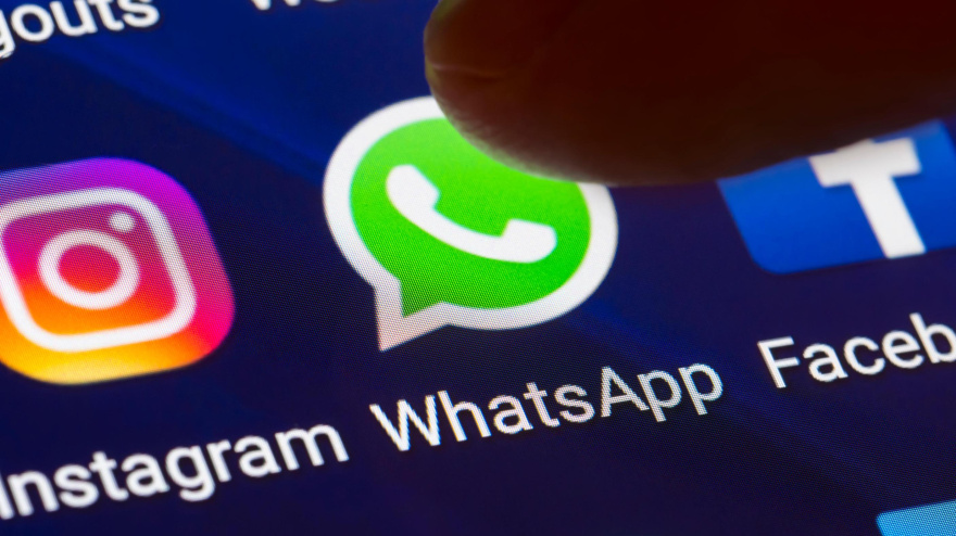 Un hombre toca el icono de WhatsApp en la pantalla de su smartphone