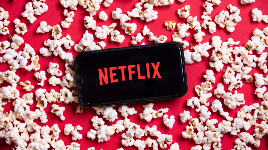 Logo de Netflix en la pantalla de un móvil con palomitas alrededor