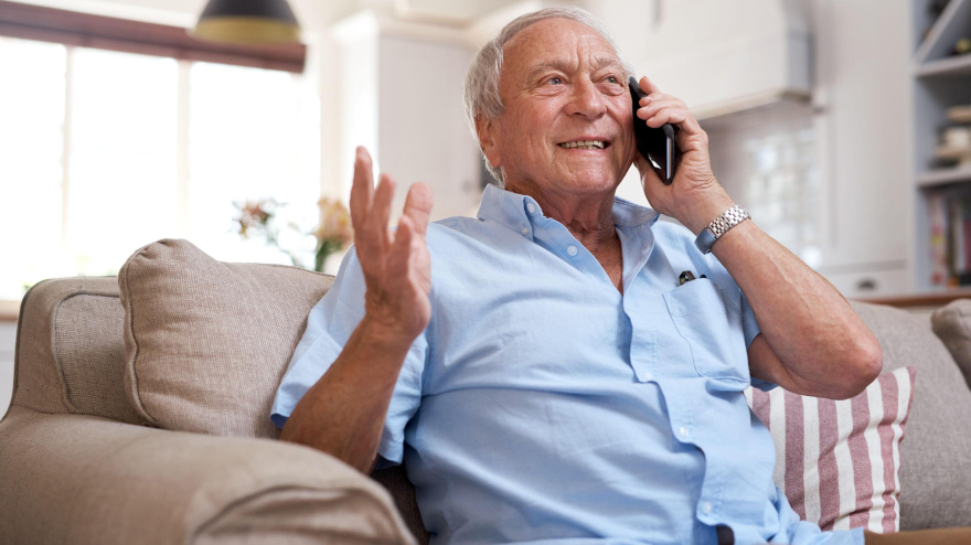 Un señor mayor hablando por teléfono contento