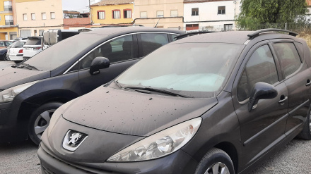 Vehículos estacionados en una calle de Lorca cubiertos de polvo subsahariano tras el episodio de calima