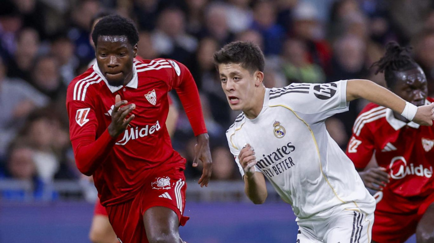 Agoumé disputa un balón con Güler durante el Real Madrid - Sevilla