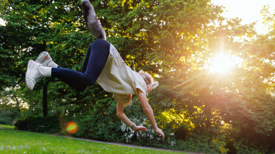 2X6D0MB Cute young little kid girl wear cat furry mask enjoy have fun playing outdoors in forest street park. Children therian wild animal character trendy