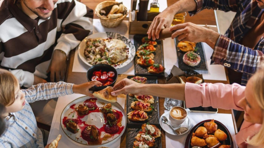 Family gathered in a restaurant to eat delicious food. They eat a variety of tasty foods.