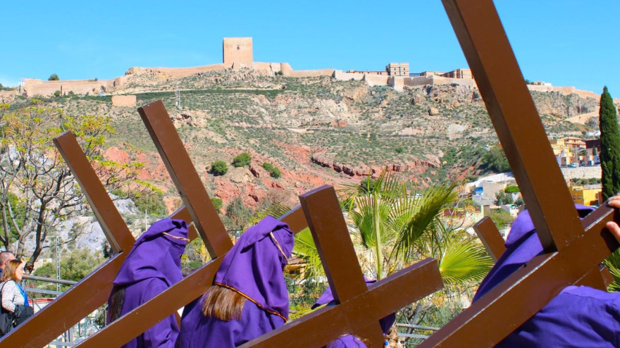 Un grupo de penitentes el Viernes Santo en el Calvario de Lorca, con el castillo de la ciudad al fondo