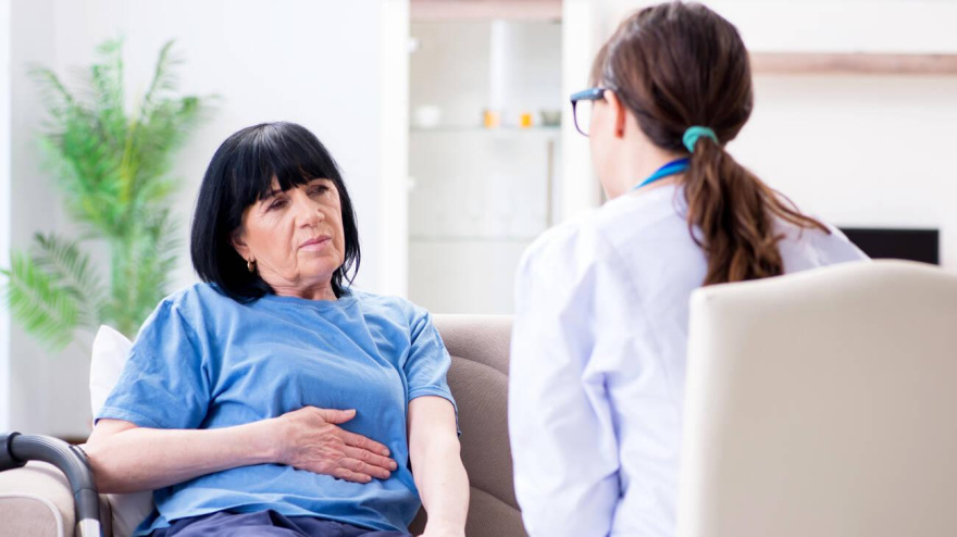 T6NNCM T6NNCM The young doctor visiting old mature woman for check-up. Image shot 09/2018. Exact date unknown.