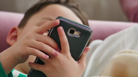 Un niño usando un teléfono móvil