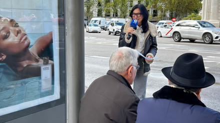 Pilar Cisneros habla con pasajeros en una de las marquesinas de la Puerta de Alcalá