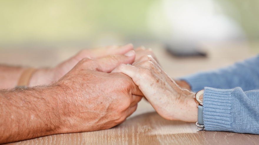 Una pareja de ancianos tomados de la mano en señal de amor, apoyo y confianza durante la jubilación, el asesoramiento y el matrimonio
