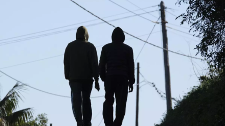 Dos jóvenes de espaldas caminando por la calle