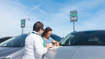 Turista firmando un contrato de alquiler de coches de Enterprise en el aeropuerto de Barcelona El Prat