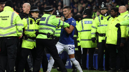 Carlos Alcaraz, jugador del Everton es agarrado por una policía inglesa para evitar que se una a la pelea.